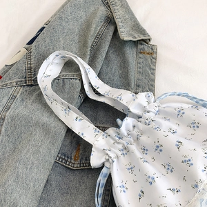 Floral and plaid drawstring tote bag with blue flower patterns on a white background