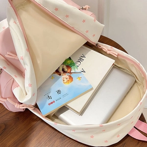 Pink and cream student backpack with star patterns showing spacious laptop compartment