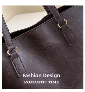 Detail of dark brown leather tote with fashion lettering and gold metal ring hardware