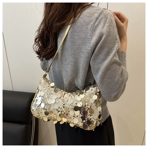 Gros plan sur le sac à bandoulière à paillettes dorées avec grands disques métalliques