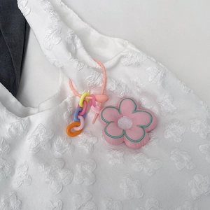 Pink plush flower charm with colorful plastic chain on a white lace tote bag