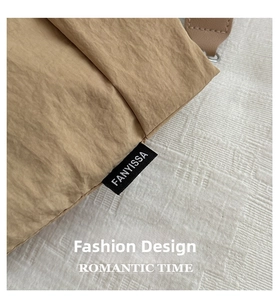 Close-up view of the durable khaki canvas fabric and FANYISSA brand tag on the bag.