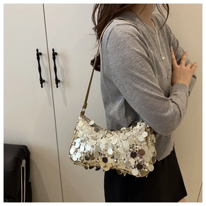 Détail des paillettes argentées scintillantes sur le sac à bandoulière baguette de luxe