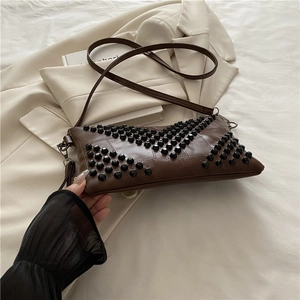 Dark brown faux leather crossbody bag with black conical studs and shoulder strap