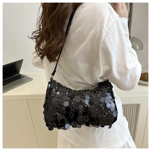 Gros plan sur les grandes paillettes noires d'un sac à bandoulière au reflet métallique