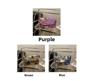 Dettaglio del ricamo floreale con paillettes su borse a tracolla in viola, marrone e blu