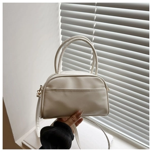 Gros plan du sac Boston blanc crème en cuir PU avec doubles poignées et sangle
