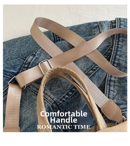 Close-up view of the durable handle and adjustable webbing strap on a casual canvas bag