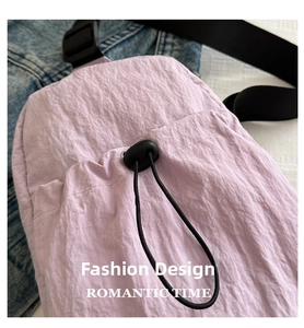 Close-up of light purple chest bag featuring crinkle texture fabric and black drawstring