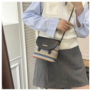 Detail of colorful rainbow straw weave and black leather flap with golden logo