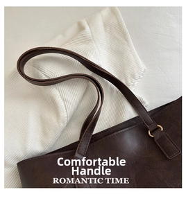 Close-up of deep brown retro leather tote with litchi texture and gold hardware rings