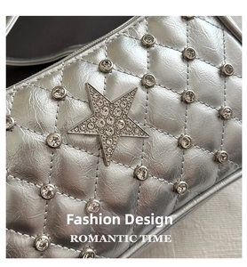 Détail du sac argenté matelassé avec étoile en strass et finition métallisée chic
