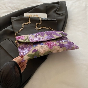 Borsa a fiori in stile cinese con paillettes e catena dorata su un blazer grigio
