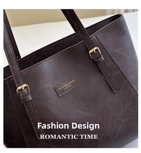Dettaglio della trama della borsa tote marrone scuro con finiture dorate e logo