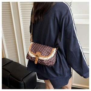 Dettaglio della borsa vintage a pois in tela con bordo in pizzo e tracolla in pelle