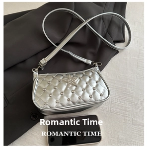Détail d'un sac à bandoulière matelassé en cuir verni argenté avec étoile en strass et motif