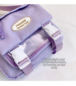 Close-up of nylon crossbody bag featuring transparent mesh pocket and snap button details