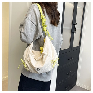 Dettaglio della borsa tote plissettata bianco sporco con lacci verde neon e testo QS FASHION