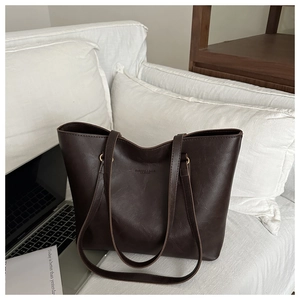 Close-up of deep brown vintage tote bag with elegant embossed text and leather texture