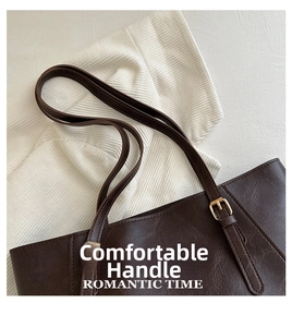 Dettaglio della fibbia dorata regolabile sulla tracolla della borsa tote in pelle marrone