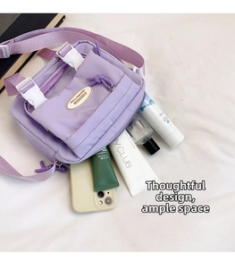 Detail of lavender nylon messenger bag showing spacious compartments and adjustable buckle