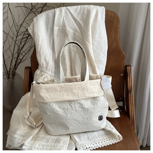 Minimalist off-white wrinkled texture canvas tote bag with adjustable shoulder strap