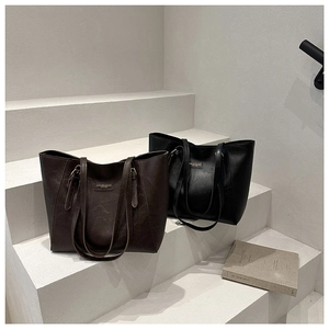 Detail of minimalist leather tote bags in black and dark brown on stylish steps
