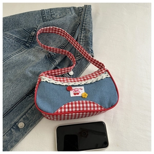 Detail of denim and red gingham shoulder bag with lace trim and cherry embroidery