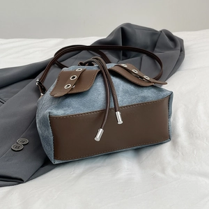 Retro denim drawstring bucket bag with brown leather trim and metal eyelet detail