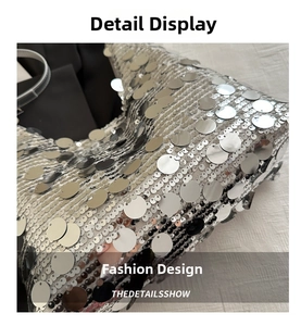 Macro detail of large silver metallic sequins layered on a stylish dumpling bag