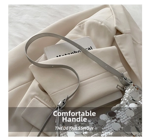 Detailed macro shot of shimmering silver sequins and sleek leather strap on a shoulder bag