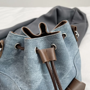 Retro light blue denim bucket bag with brown leather drawstring and silver metal eyelets