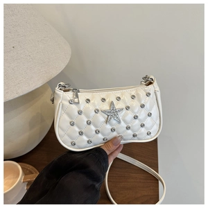 Détail macro d'un sac blanc matelassé avec étoile en strass brillante et fermeture argentée