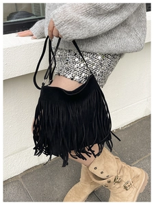 Detail of black fringe shoulder bag showing long swaying tassels and soft suede texture