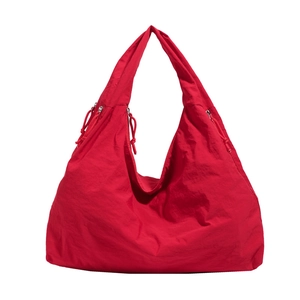 Large red nylon tote bag with drawstring sides and wide shoulder strap for daily travel