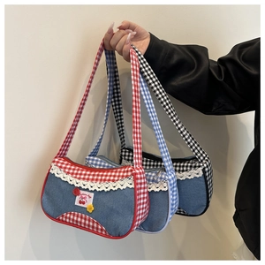 Close-up of three denim handbags with red, blue, and black plaid texture and lace trim