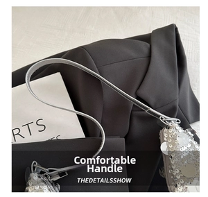 Detail of silver sequin handbag with round scales and sleek metallic zipper puller