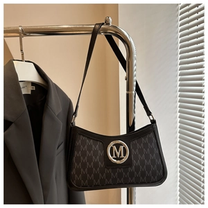 Detail of vintage retro monogram shoulder bag hanging with stylish metal logo and silver buckle