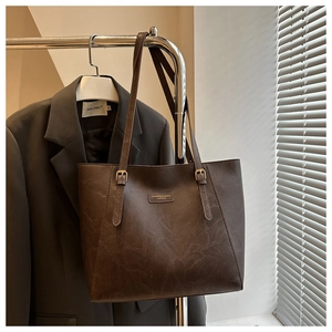 Dettaglio della borsa tote marrone scuro con tracolla regolabile e texture vintage