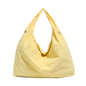 Grand sac hobo en nylon jaune clair avec détails de cordon réglable sur fond blanc