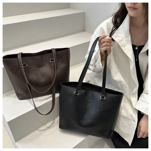 Close-up of matte faux leather tote bag with debossed logo and dual shoulder straps