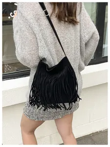 Detail shot of the long black tassels and adjustable silver buckle on a boho crossbody bag