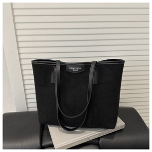 Detail of black suede tote bag with FANYISSA BAGS logo and leather shoulder straps