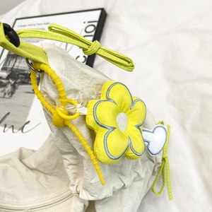 Borsa hobo in tela plissettata bianco sporco con ciondolo a fiore giallo e fiocchi laterali