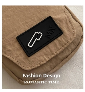 Detail of khaki nylon fabric with FANVISSA BAG rubber logo patch and fine stitching