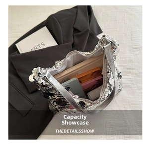 Detail view of large capacity interior for silver sequined shoulder bag with daily essentials