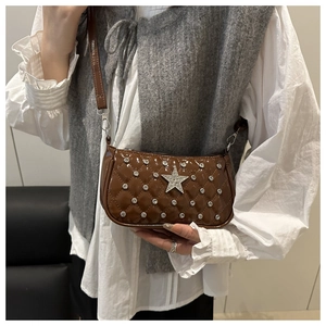 Detail of brown patent leather bag with quilted pattern, silver studs and star emblem