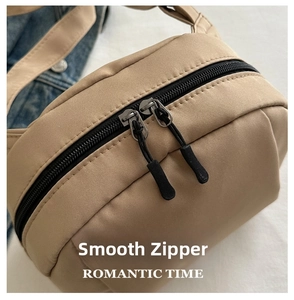 Detailed macro view of high-quality smooth dual-direction zippers on the khaki nylon bag