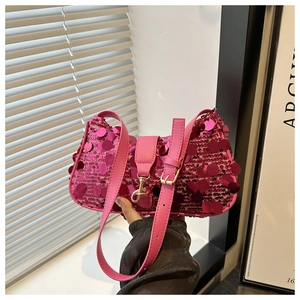Detail of hot pink sequined shoulder bag featuring glossy texture and adjustable leather strap