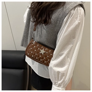 Close-up of brown quilted patent leather shoulder bag with a sparkling silver star